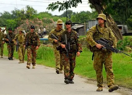 Soldiers walking a rural road — the military history of East Timor that haunts Wolf throughout Islands of the Heart